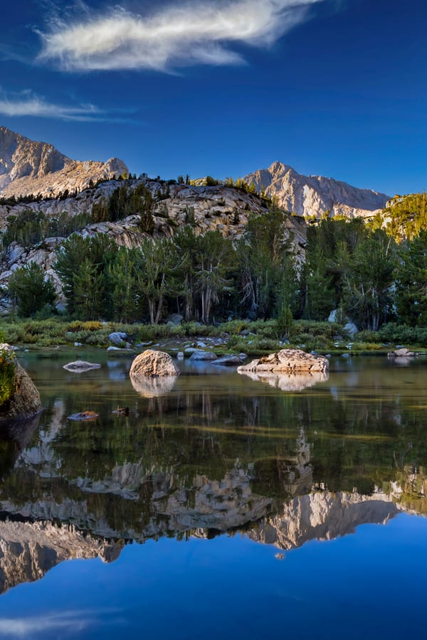 Mountain lake with granite peaks reflected in still water
